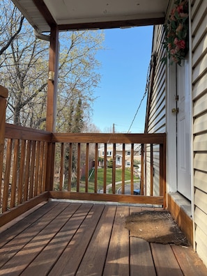 A wooden deck with a railing, a clear view of the neighborhood, and a house with siding. - Cozy 2-bedroom apartment in quaint South Amboy with AC (South Amboy)