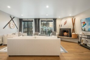 Un salon moderne avec un grand canapé, une cheminée et une vue sur la ville.