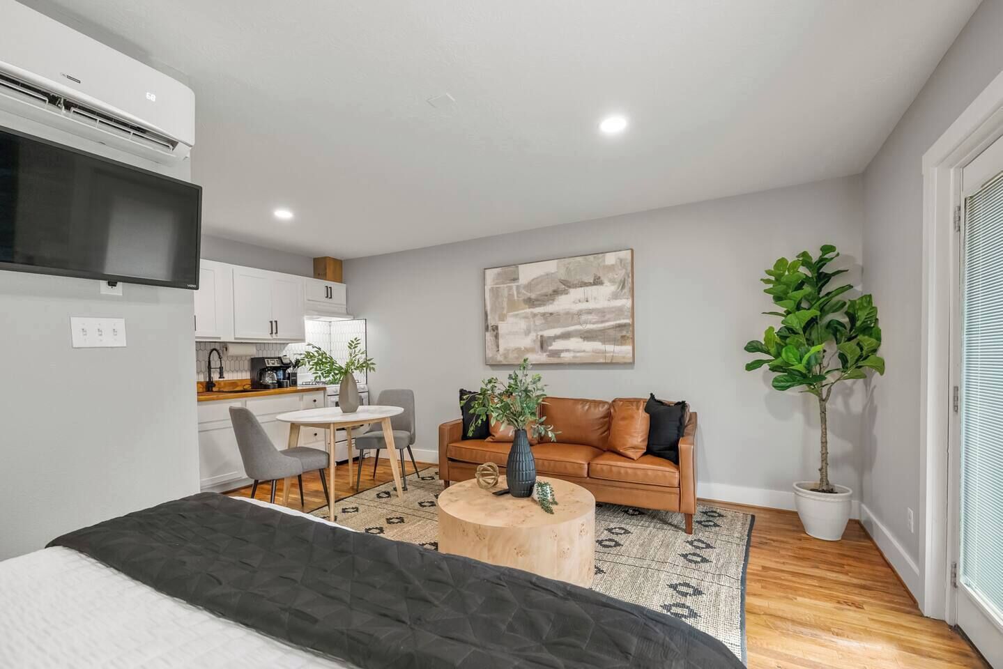 Un salon moderne comprenant un canapé, une table basse et un coin repas avec des chaises et une table.