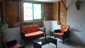 Une pièce comprenant un canapé, des fauteuils, une table basse et une fenêtre donnant sur un paysage agréable.