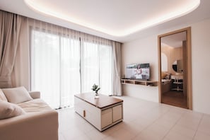 Ein modernes Wohnzimmer mit einer Couch, einem Couchtisch, einem Fernseher und einem Spiegel.