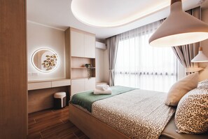 Ein modernes Schlafzimmer mit Bett, Nachttischen, einem Schminktisch mit Spiegel und einem Fenster mit Vorhängen.