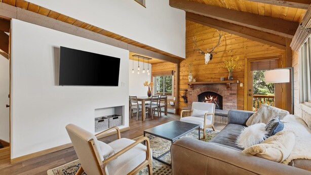 A modern living room with a fireplace, a TV mounted on the wall, and a cozy seating area. - Cozy Duplex in West Vail – Near Vail Village (Vail)