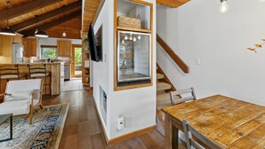 A modern kitchen with wooden cabinets, a built-in island, and a dining area with a wooden table and chairs. - Cozy Duplex in West Vail – Near Vail Village (Vail)