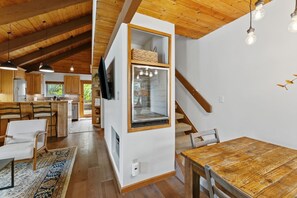 A modern kitchen with wooden cabinets, a built-in island, and a dining area with a wooden table and chairs. - Cozy Duplex in West Vail – Near Vail Village (Vail)