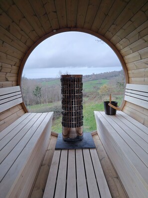 Una estructura circular de madera con vistas a un paisaje verde.