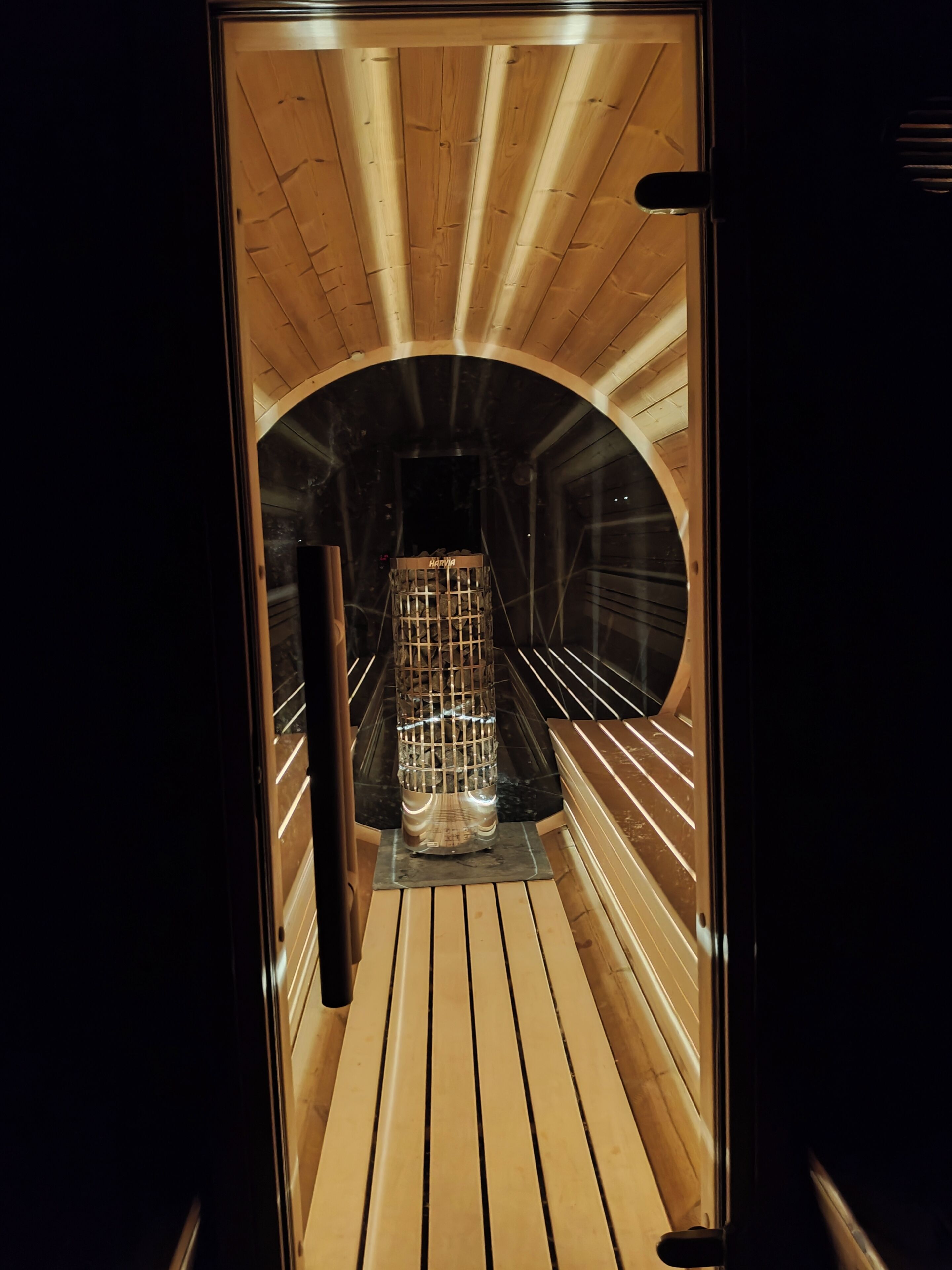 A sauna with a wooden interior and a glass enclosure.