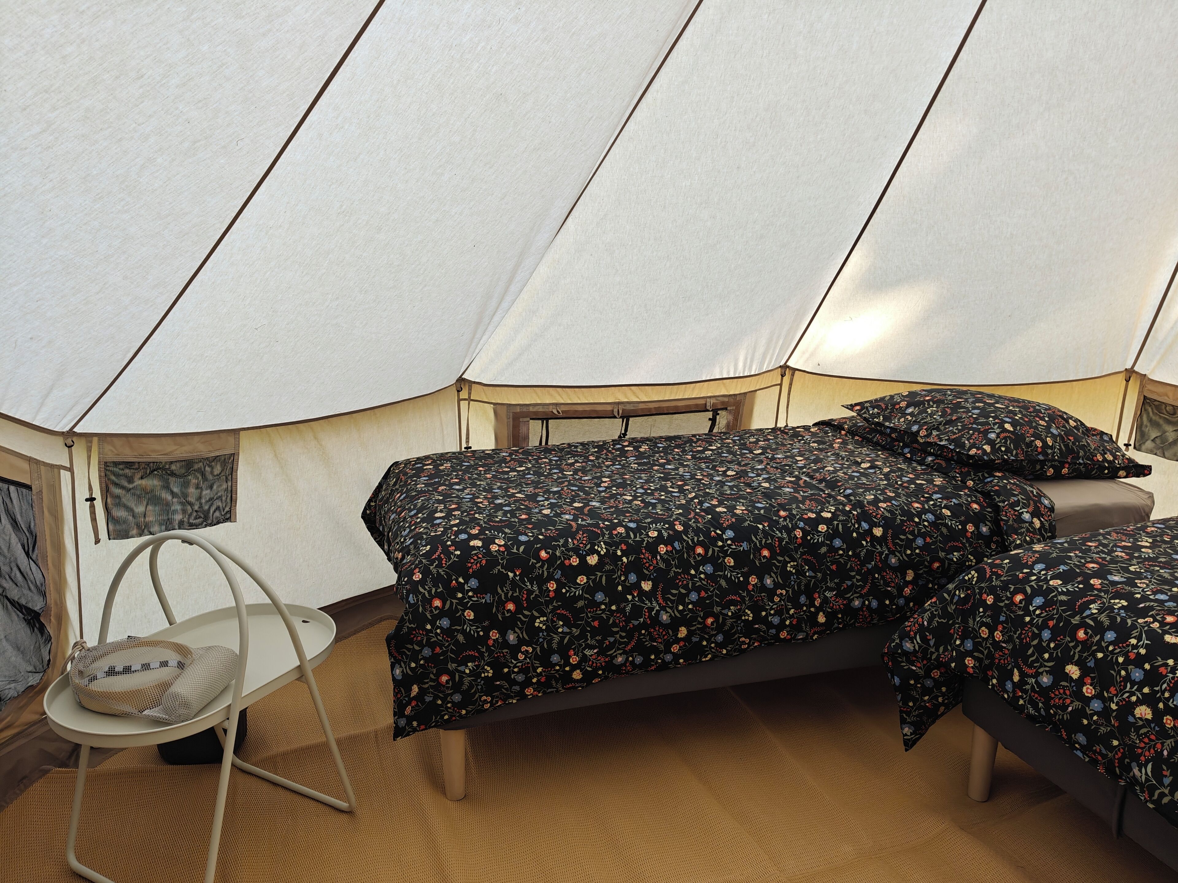 A tent with a bed, a chair, and a small table.