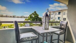 A balcony with two chairs, a table, and a decorative lantern.