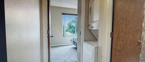 A doorway leading to a room with a visible window and a view of a tree outside.