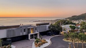 A modern building with a view of the ocean at sunset. - Room-luxury Couples Suite Ocean View & (Cape Town)