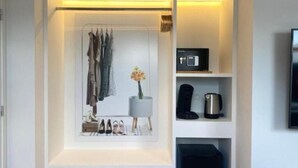 A modern, well-organized walk-in closet with built-in shelves, a vanity, and a coffee machine. - Fashion Brussels (Brussels)