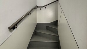 A staircase with a handrail and a light fixture at the top. - Fashion Brussels (Brussels)