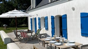 A white building with blue shutters, a wooden deck, and outdoor furniture. - Belle-Île-en-Mer — Large family home 12 pers · Garden · 5 min from Donner (Bangor)