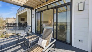 Ein Balkon mit zwei Liegestühlen und einer Pergola.