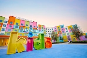 Un edificio colorido con el letrero 'UNIVERSAL kids' y una zona de juegos infantiles.