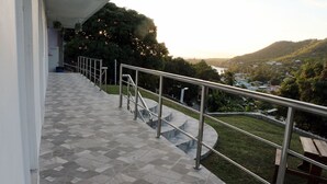 A terrace with a metal railing, a tiled floor, and a view of a hilly landscape. - Cozy 1-bedroom apartment in beautiful Laborie with AC (Laborie)