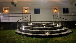 A building with a central staircase, multiple doors with illuminated numbers, and a well-lit exterior. - Cozy 1-bedroom apartment in beautiful Laborie with AC (Laborie)