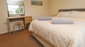 A bedroom with a bed, a desk, a chair, and a painting on the wall. - Gelli - Morfa Nefyn (Pwllheli)