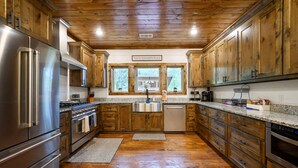 A kitchen with wooden cabinets, stainless steel appliances, and a granite countertop. - The Retreat at Red Fern - Excellent Location (Broken Bow)