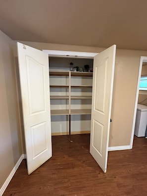 A walk-in closet with open doors, wooden flooring, and a white door frame. - Roomy 4-bedroom house with large backyard in Abilene (Abilene)