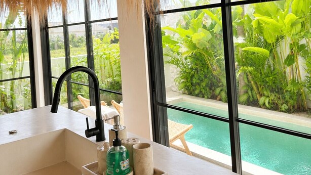 A bathroom with a large window, a sink, and a bottle of hand soap. - 2BR Private Pool Villa • Near Cemagi Beach & Canggu (Badung)