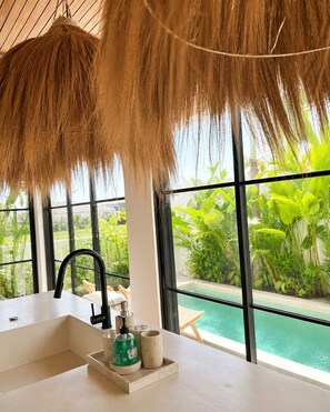 A bathroom with a large window, a sink, and a bottle of hand soap. - 2BR Private Pool Villa • Near Cemagi Beach & Canggu (Badung)