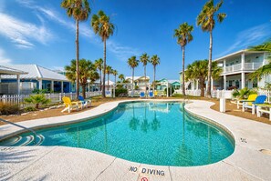 A pool with a 'NO DIVING' sign, surrounded by palm trees and beach houses. - *NEW* No Stairs|Pool|Pet Friendly! (Port Aransas)