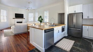 Una cucina moderna con isola centrale, elettrodomestici in acciaio inossidabile e mobili bianchi.