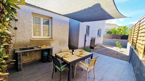 Eine Terrasss mit Essplatz, Spüle und Fenster.