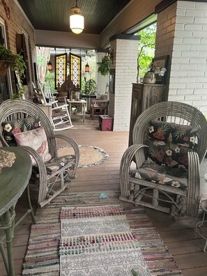 A covered porch with wicker furniture, a patterned rug, and a brick wall. - World Cup rental.  Dallas 3BR historic home 20 minutes to World Cup stadium. (Dallas)