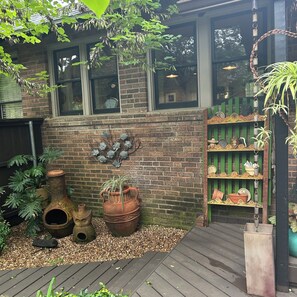 A brick building with large windows, a wooden deck, and decorative pots and plants. - World Cup rental.  Dallas 3BR historic home 20 minutes to World Cup stadium. (Dallas)