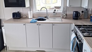 Une cuisine moderne équipée d’un four à micro-ondes, d’une cuisinière et d’un évier intégrés.