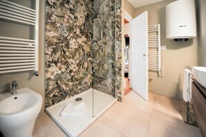 Ein Badezimmer mit Dusche, Bidet und Toilette.