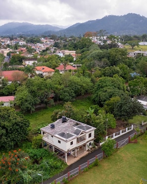 A residential area with houses surrounded by greenery and mountains in the background. - Brisa del Rio Jimenoa (Jarabacoa)