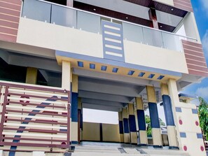 Un edificio a più piani con un ingresso ben visibile, una tettoia e un’area recintata.