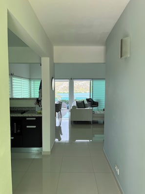 Ein modernes Interieur mit Küche, Essbereich und Wohnzimmer, mit einem großen Fenster und Blick.