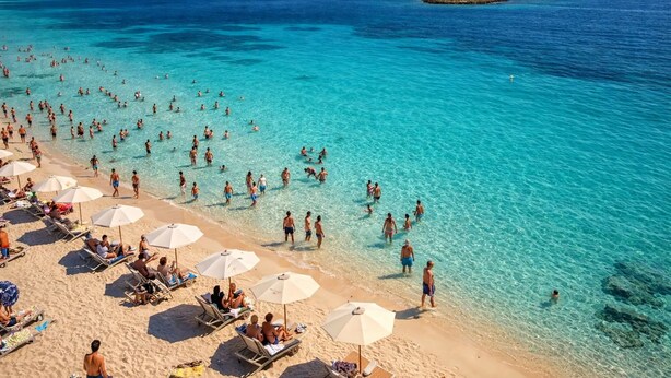 A beach with clear turquoise water, sun loungers, and umbrellas. - Monolocale Alba Salentina Nuovo, Elegante e Vicino al Mare (Nardò)