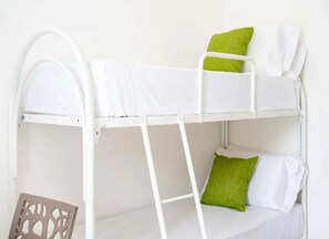 A bunk bed with white bedding and green pillows. - Monolocale Alba Salentina Nuovo, Elegante e Vicino al Mare (Nardò)