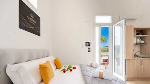 A modern bedroom with a bed, pillows, and a view of the outside. - Monolocale Alba Salentina Nuovo, Elegante e Vicino al Mare (Nardò)