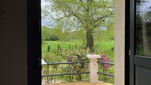 A wooden deck with a railing, a table, and a tree in the background. - New 2-⭐️ cottage on a Loire island, ideal for families (Gennes-Val-de-Loire)