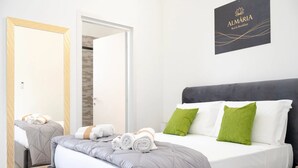 A hotel room with a bed, a mirror, a wall-mounted sign, and a door. - Monolocale Riva Wi-fi, Clima e Giardino a Torre Lapillo (Nardò)