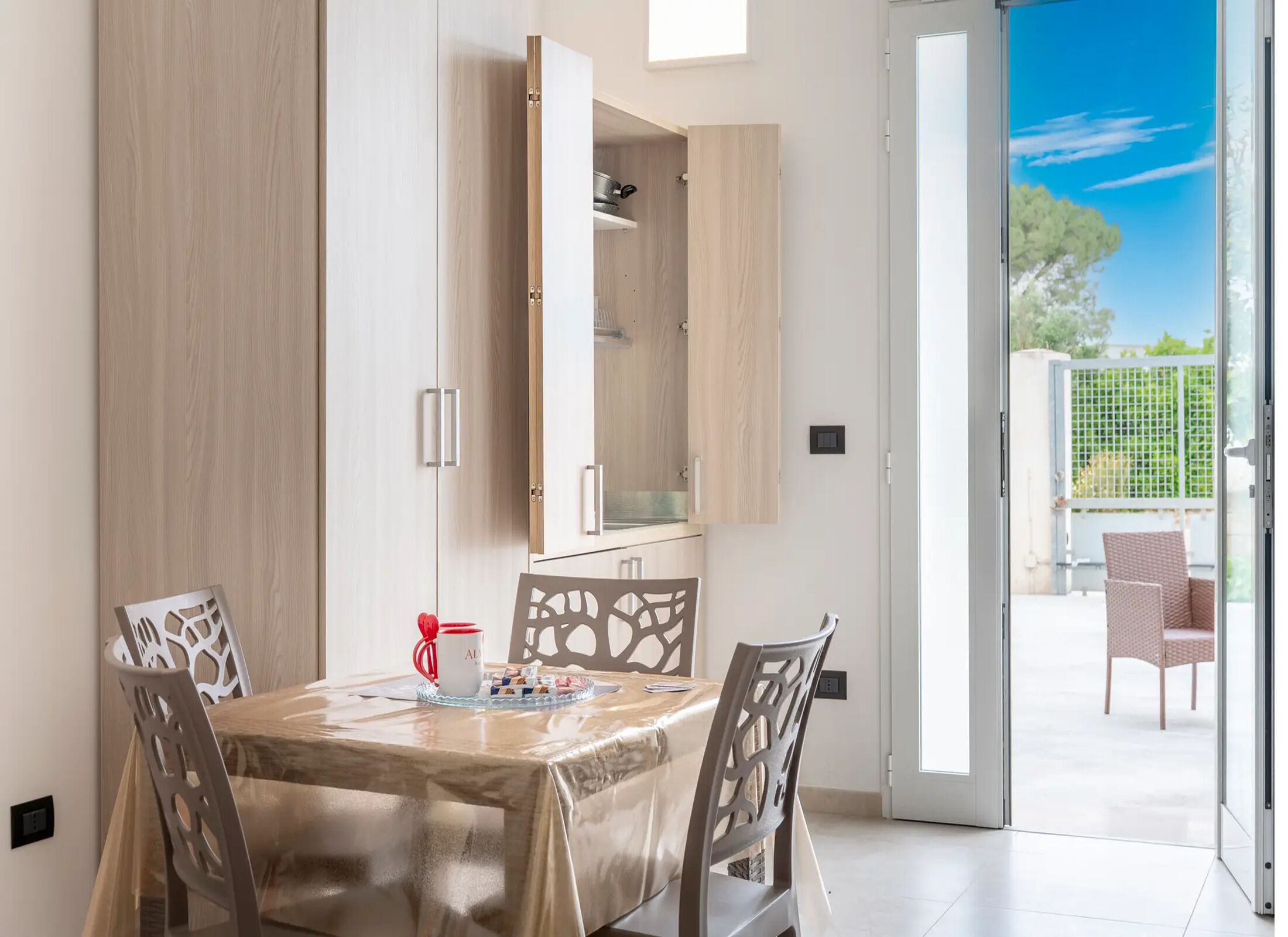 A dining area with a table, chairs, and a sliding glass door leading to an outdoor seating area.