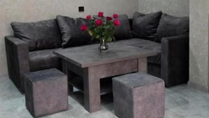 A modern living room with a sectional sofa, a coffee table, and matching ottomans. - Livana Guesthouse  (Goris)