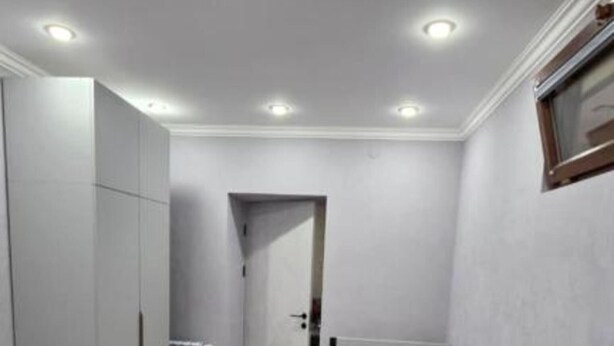 A narrow room with two beds, a wardrobe, and a radiator. - Livana Guesthouse  (Goris)