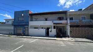 Un edificio de dos pisos con puerta de garaje, el número '21' visible y una entrada con reja.