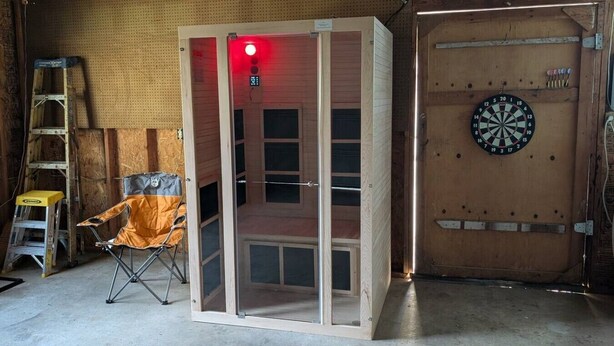 A room with a dartboard, a folding screen, and a ladder. - Cozy GP Retreat, Sauna + King Size Bed (Grants Pass)