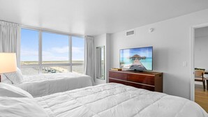 A hotel room with two beds, a TV, and a view of the beach. - Cozy Water Views Apt Fort Myers (Fort Myers)