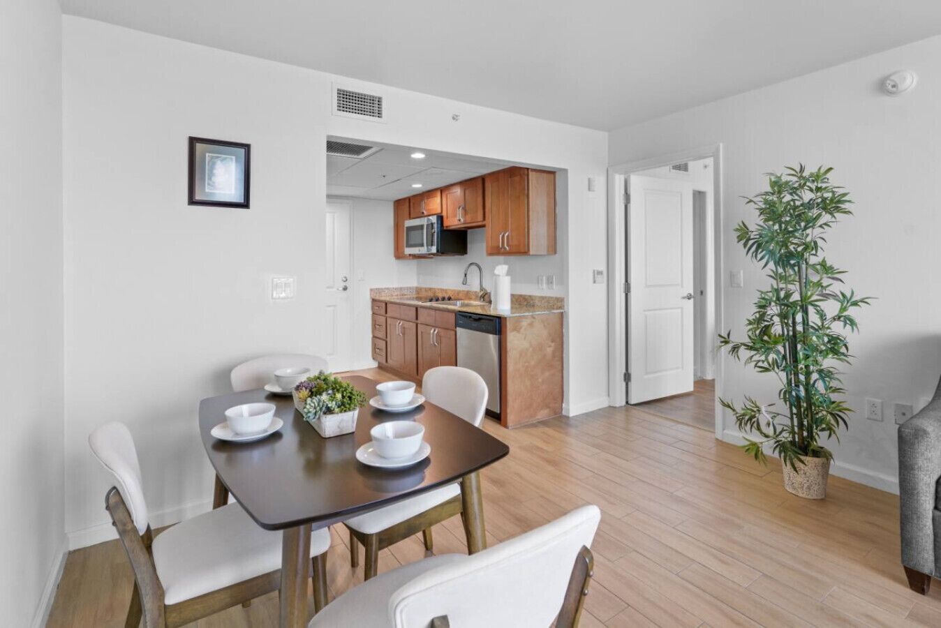 A modern apartment with a dining area, kitchen, and a living space.