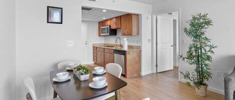 A modern apartment with a dining area, kitchen, and a living space.